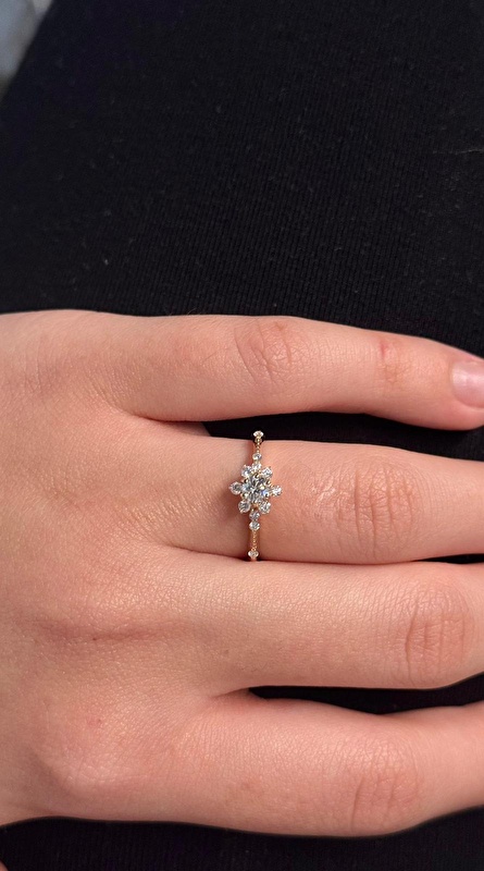 Lotus tasarımı parmakta çok zarif duruyor, pırlantanın ışıltısı hemen fark ediliyor. 0,62 karat olması tam kararında bir dolgunluk veriyor.