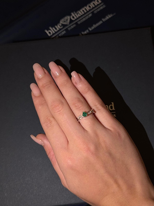 Zümrüdün derin yeşil tonu pırlantanın ışıltısıyla çok zarif bir uyum yakalıyor. Sonsuzluk formu yüzüğe hem anlamlı hem şık bir duruş katıyor.