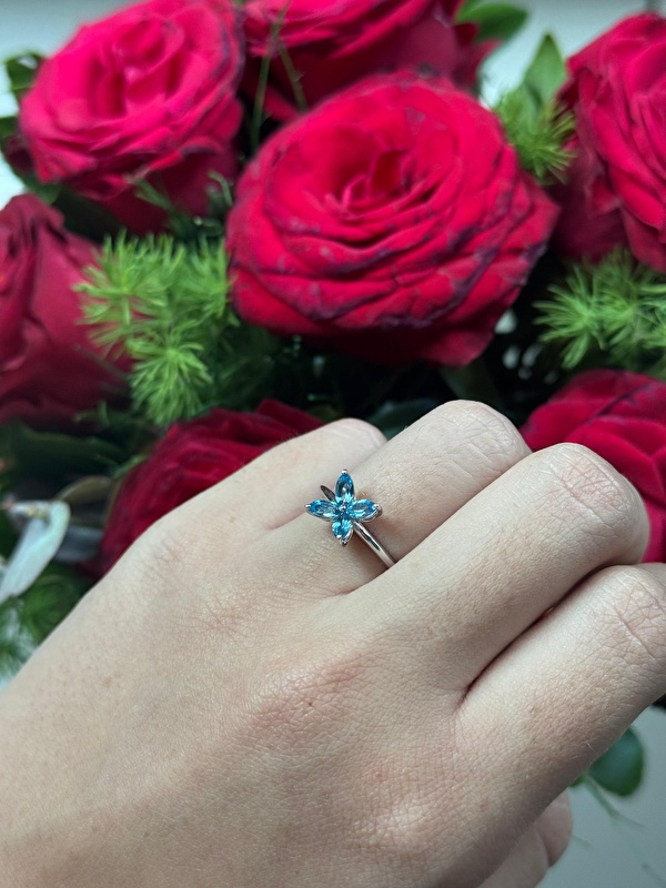 Blue topazın ferah mavi tonu yüzüğe çok farklı bir enerji katıyor. Çiçek formu da bu rengi daha canlı ve zarif gösteriyor.