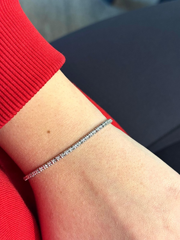 Denedim, bilekte akışı gerçekten çok zarif duruyor. Pırlantalar ışığı yakaladıkça su yolu formu daha da ortaya çıkıyor.