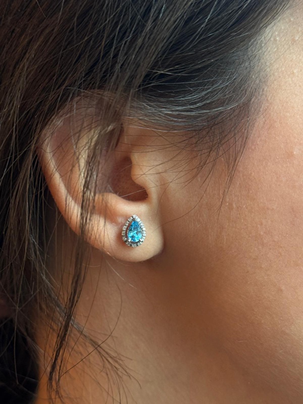 Blue topazın canlı mavisi ve pırlantaların ışıltısı çok zarif bir uyum sunuyor. Kulağa takıldığında hem ferah hem şık bir görünüm veriyor.